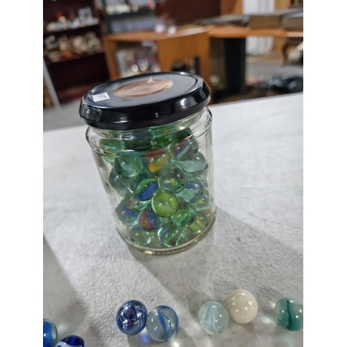 49 - 2x Jars of marbles of various designs inc iridescent marbles, green and white marbles etc, please se... 