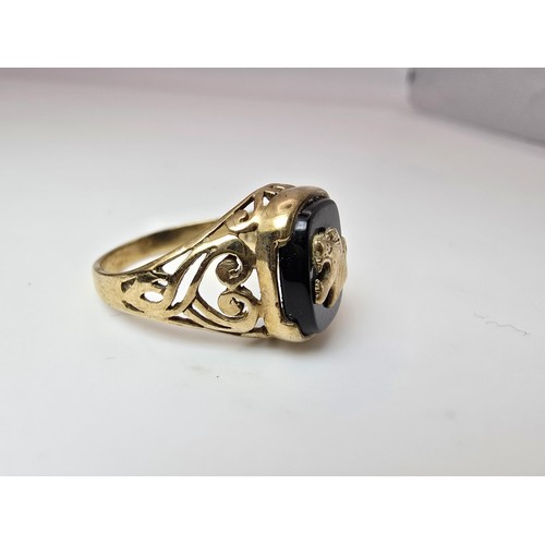 252 - A stunning hallmarked 9ct yellow gold unisex signet ring featuring a black onyx stone with an overla... 