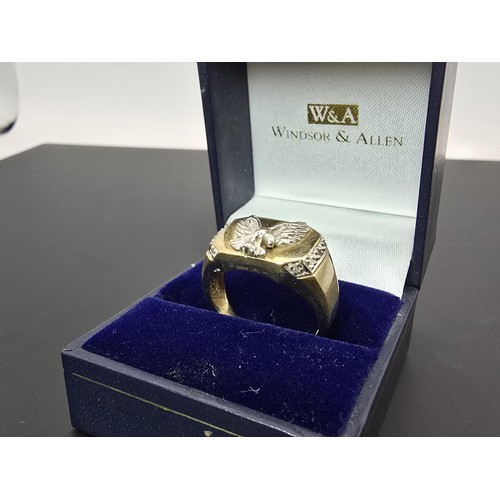 253 - An attractive hallmarked 9ct yellow gold gents signet ring featuring a pretty white gold overlaid ea... 