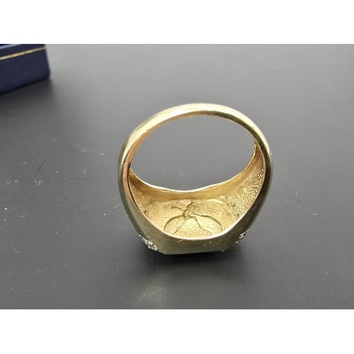 253 - An attractive hallmarked 9ct yellow gold gents signet ring featuring a pretty white gold overlaid ea... 