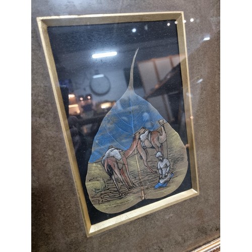 133 - Framed and glazed hand painted in oil colours painting on a real skeleton Pipal tree leaf of a deser... 