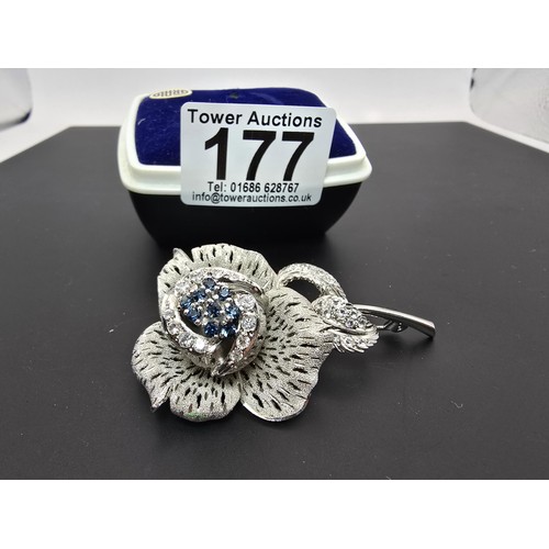 177 - A very pretty ornate silver tone rose formed brooch inset with blue crystals and clear crystals, the... 