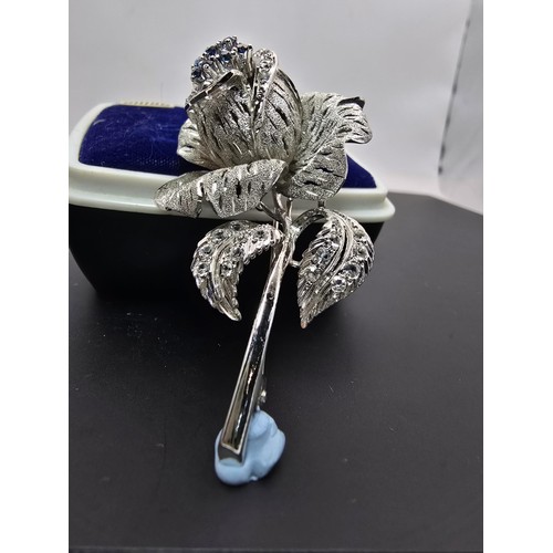 177 - A very pretty ornate silver tone rose formed brooch inset with blue crystals and clear crystals, the... 