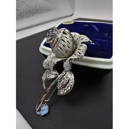 177 - A very pretty ornate silver tone rose formed brooch inset with blue crystals and clear crystals, the... 