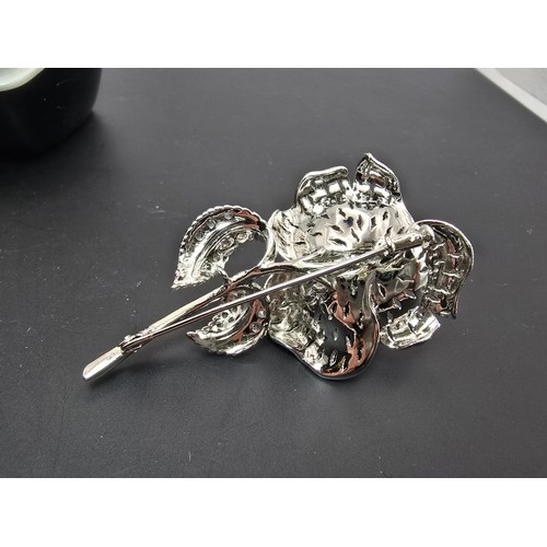 177 - A very pretty ornate silver tone rose formed brooch inset with blue crystals and clear crystals, the... 