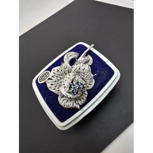 177 - A very pretty ornate silver tone rose formed brooch inset with blue crystals and clear crystals, the... 