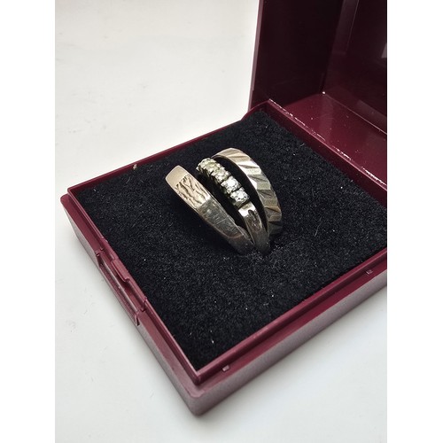 193 - A bundle of 4x 925 silver rings in various designs which includes a 5 stone ring inset with crystal ... 