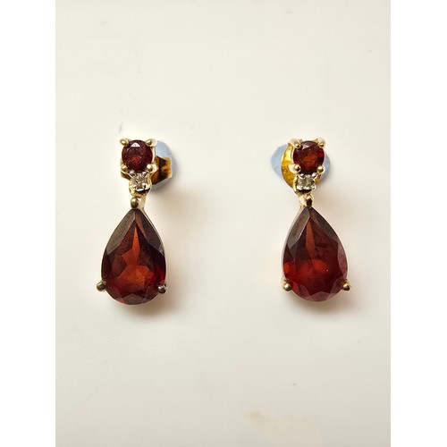 262 - A pair of pretty 10ct yellow gold drop earrings inset with stunning almandine garnet faceted gemston... 