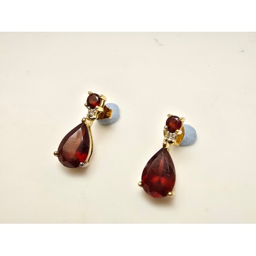 262 - A pair of pretty 10ct yellow gold drop earrings inset with stunning almandine garnet faceted gemston... 