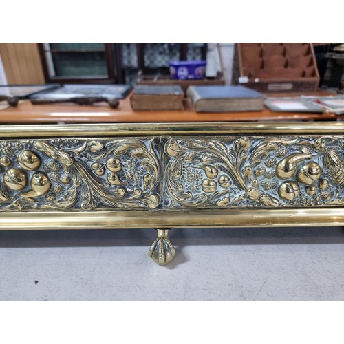 307 - Good quality antique brass fire fender, with intricate pine cone and oak leaf decoration to the fron... 