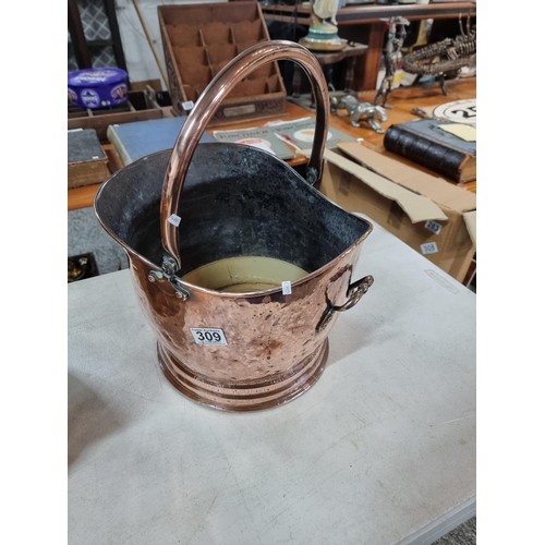 309 - Good quality copper coal scuttle with hammered decoration along with a large brass planter style log... 