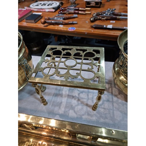 313 - Large collection of brass items inc a large brass ornate fender with paw feet style corners, tall br... 