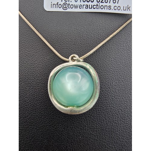 215 - An unusual pendant inset with a blue Beryl cats eye stone in the form of a ball on an 18