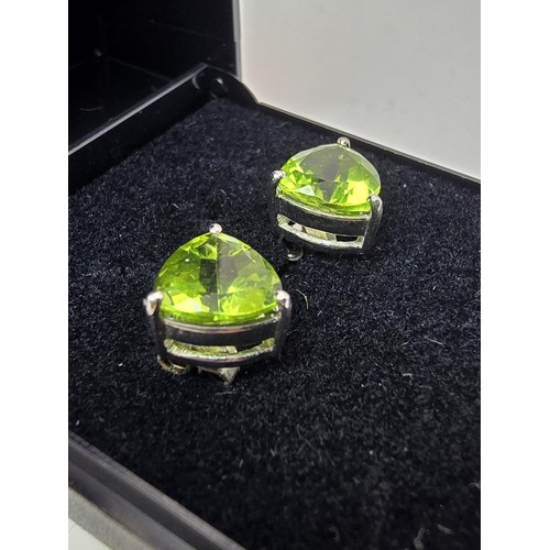 213 - A pair of 925 silver stunning statement stud earrings inset with large faceted peridot stones presen... 