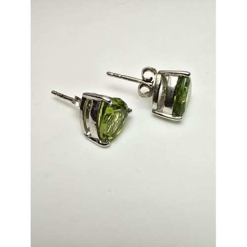 213 - A pair of 925 silver stunning statement stud earrings inset with large faceted peridot stones presen... 