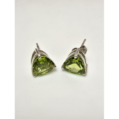 213 - A pair of 925 silver stunning statement stud earrings inset with large faceted peridot stones presen... 