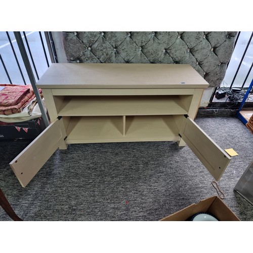 380 - Good quality wooden cream coloured TV unit with shelf to the front and two doors beneath, in good ov... 