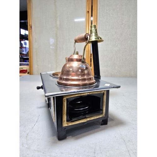 286 - A miniature metal operational stove featuring a copper kettle and a copper frying pan an 2 burners o... 