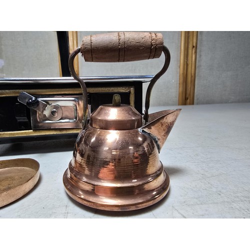 286 - A miniature metal operational stove featuring a copper kettle and a copper frying pan an 2 burners o... 