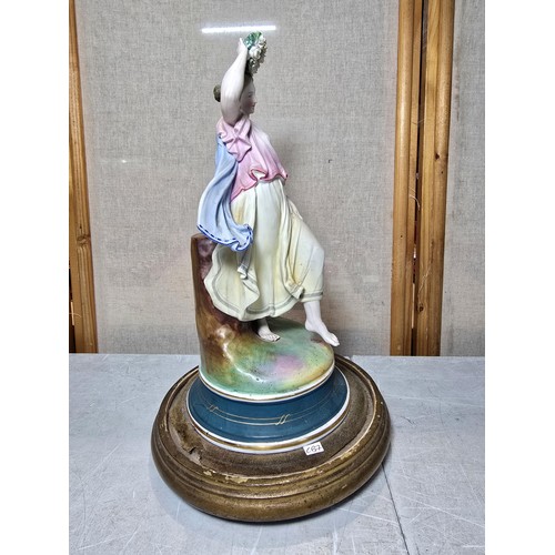 296 - A good quality antique Victorian porcelain figurine of a lady holding a Wreath standing on a wooden ... 