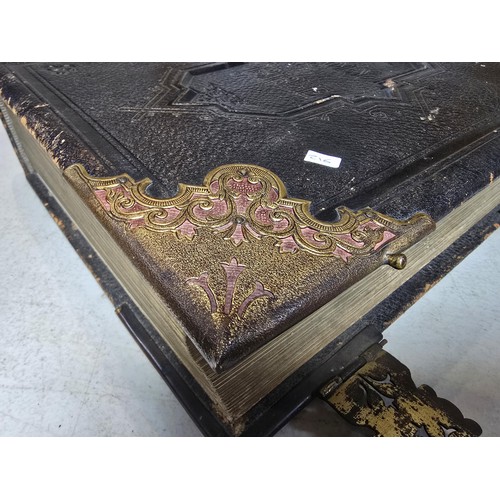 294 - A large antique family holy bible with a black leather hard cover featuring gilt and ornate corners ... 