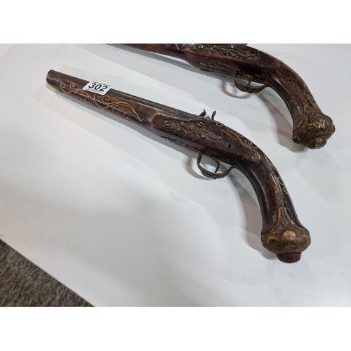 302 - Pair of replica 18th century flint lock, the pistols are made from wood with an iron barrel and hamm... 