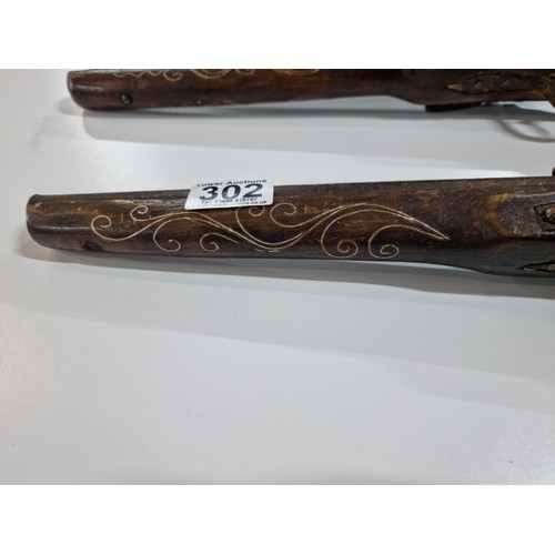 302 - Pair of replica 18th century flint lock, the pistols are made from wood with an iron barrel and hamm... 