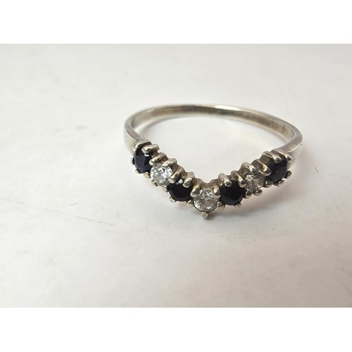 219 - An ornate 925 silver wishbone ring inset with 4 sapphire stones and 3 sparkly CZ stones. The ring is... 