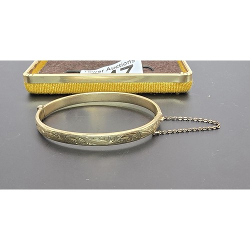 247 - A vintage 9ct yellow gold with metal core hinged bangle having an engraved design to one side, clasp... 