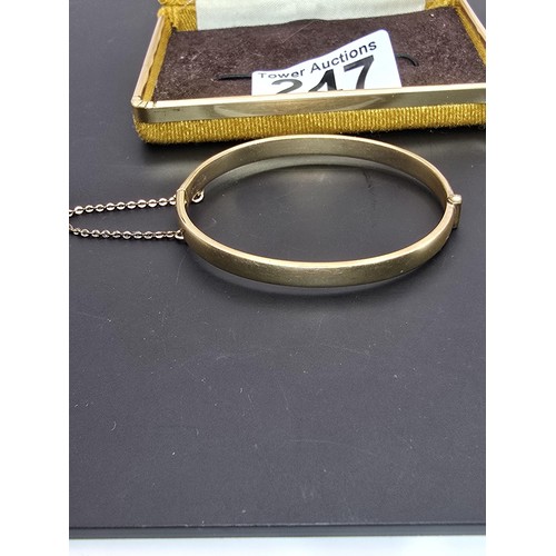 247 - A vintage 9ct yellow gold with metal core hinged bangle having an engraved design to one side, clasp... 