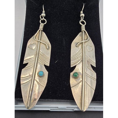 177 - A pair of large 925 silver long drop earrings in the form of Navajo feathers, inset with a turquoise... 