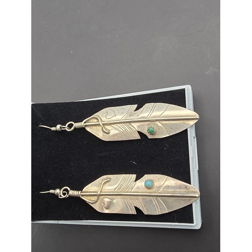 177 - A pair of large 925 silver long drop earrings in the form of Navajo feathers, inset with a turquoise... 