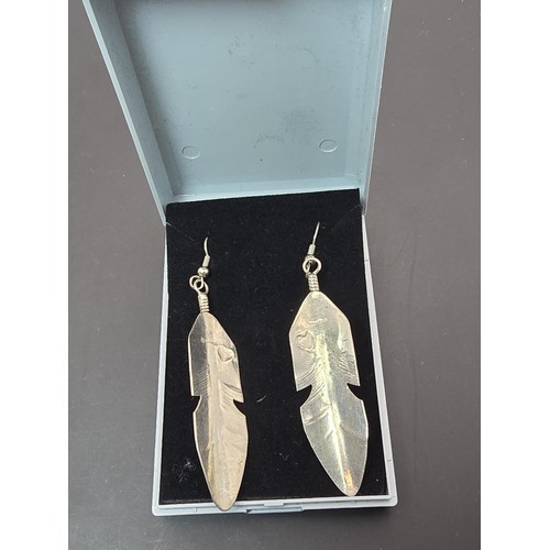 177 - A pair of large 925 silver long drop earrings in the form of Navajo feathers, inset with a turquoise... 