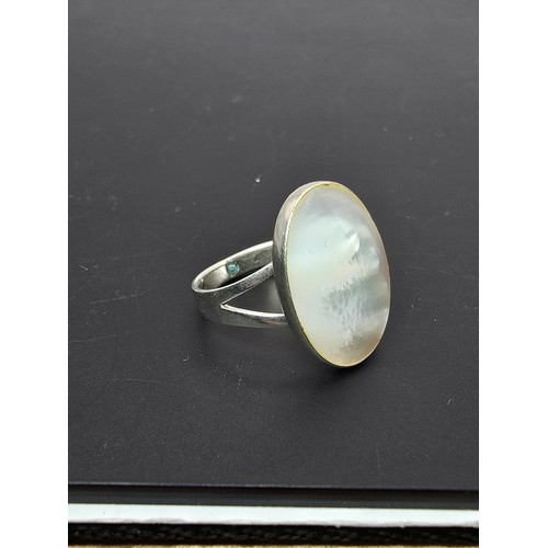 187 - Pretty 925 Silver ring inset with a large oval mother of pearl stone which flashes beautifully in th... 