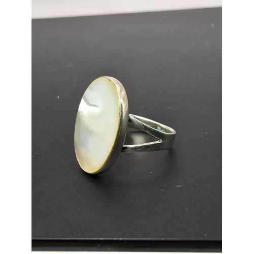 187 - Pretty 925 Silver ring inset with a large oval mother of pearl stone which flashes beautifully in th... 