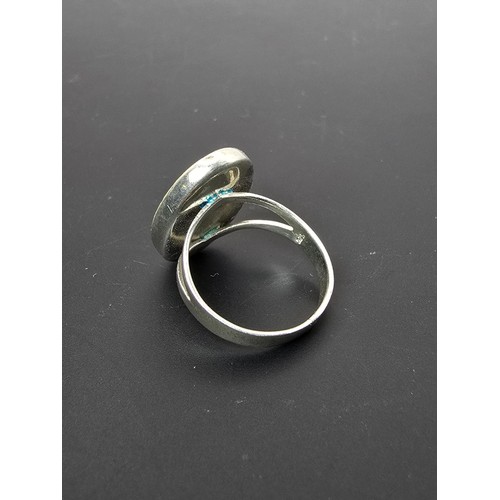 187 - Pretty 925 Silver ring inset with a large oval mother of pearl stone which flashes beautifully in th... 