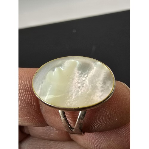 187 - Pretty 925 Silver ring inset with a large oval mother of pearl stone which flashes beautifully in th... 