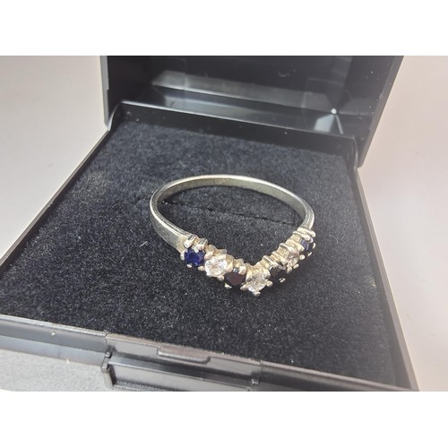 215 - An ornate 925 silver wishbone ring inset with 4 sapphire stones and 3 sparkly CZ stones. The ring is... 