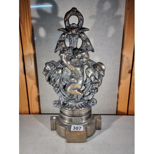 307 - Good quality cast iron door stop in the form a cherub with a garland formed ring to the top, in good... 