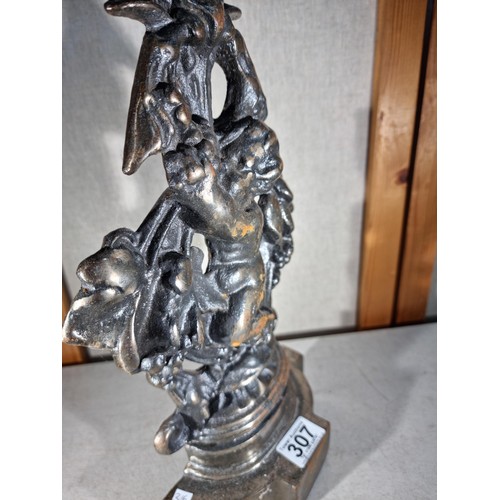 307 - Good quality cast iron door stop in the form a cherub with a garland formed ring to the top, in good... 