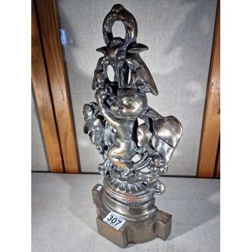 307 - Good quality cast iron door stop in the form a cherub with a garland formed ring to the top, in good... 