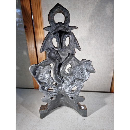 307 - Good quality cast iron door stop in the form a cherub with a garland formed ring to the top, in good... 