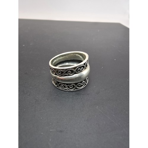 194 - Chunky 925 Silver ring having an ornate wirework design with a solid band in the centre in clean con... 