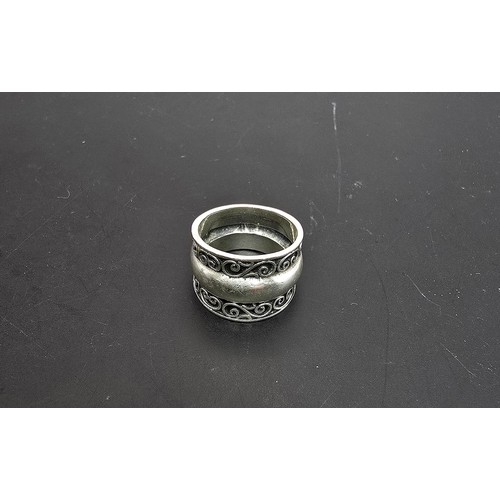 194 - Chunky 925 Silver ring having an ornate wirework design with a solid band in the centre in clean con... 