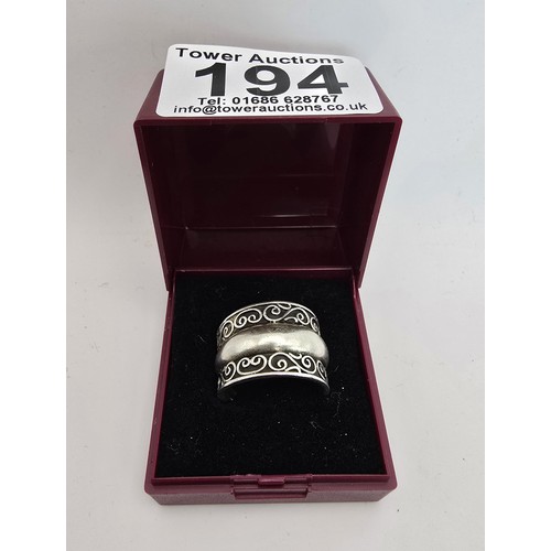 194 - Chunky 925 Silver ring having an ornate wirework design with a solid band in the centre in clean con... 