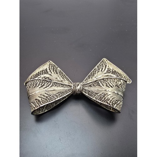 223 - A large and impressive 925 silver bow formed brooch with an intricate filigree design, the brooch di... 