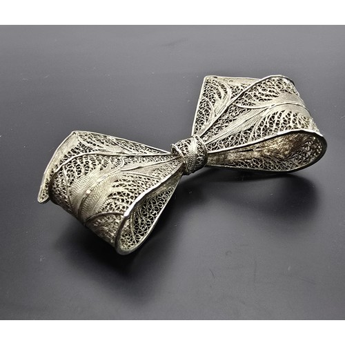 223 - A large and impressive 925 silver bow formed brooch with an intricate filigree design, the brooch di... 