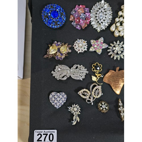 270 - A suite of approx 24 vintage ornate brooches on a display stand which is included featuring an ornat... 