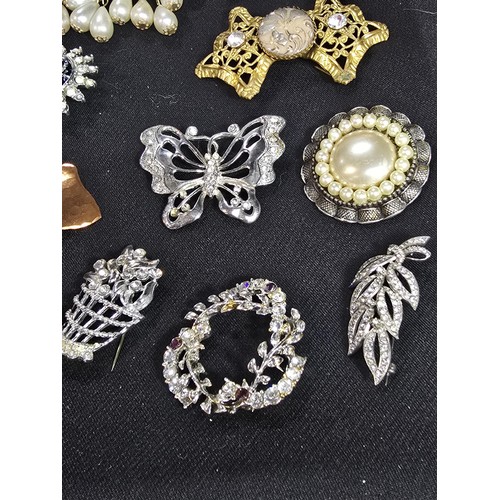 270 - A suite of approx 24 vintage ornate brooches on a display stand which is included featuring an ornat... 