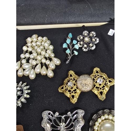 270 - A suite of approx 24 vintage ornate brooches on a display stand which is included featuring an ornat... 